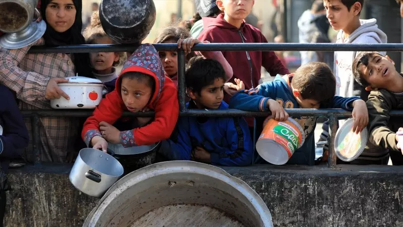 12/03/2024 Palestinos esperan a que lleguen alimentos de socorro en la ciudad de Rafah, en el sur de la Franja de Gaza, a 14 de febrero de 2024.