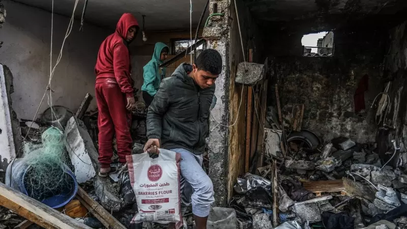 13/03/2024 Un niño palestino saca una bolsa de harina de una casa destruida tras un ataque aéreo israelí.