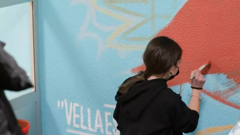 Alumnos de un colegio pintando un mural.