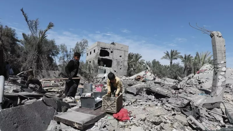 15/03/2024 Varios palestinos tratan de recoger sus pertenencias utilizables alrededor de los restos tras un ataque israelí en Dair El-Balah, Gaza, a 13 de marzo de 2024.