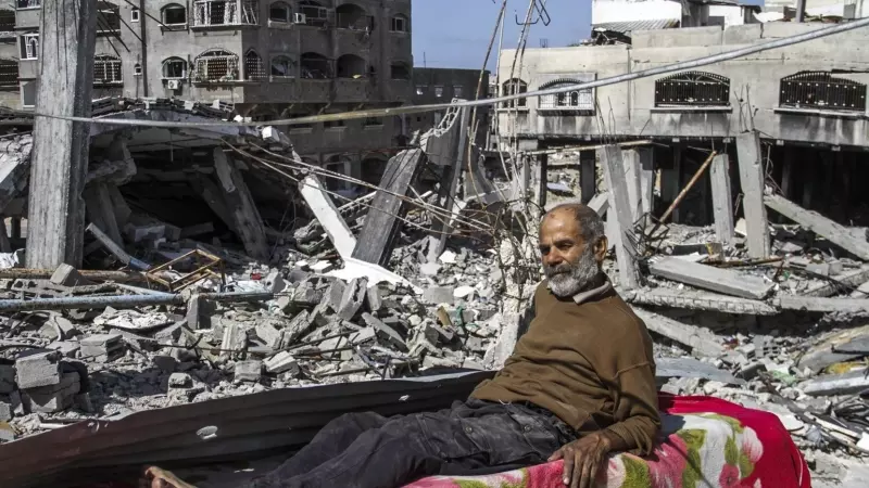 Un hombre tumbado sobre los escombros tras los ataques israelíes.