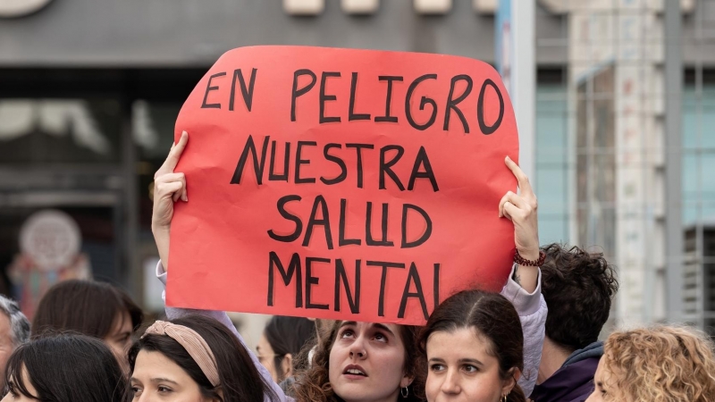 Una joven sujeta una pancarta durante una manifestación