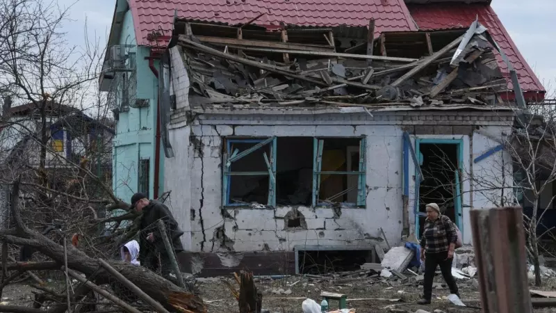 Varios vecinos caminan entre los escombros de una casa tras un ataque ruso en Ucrania.