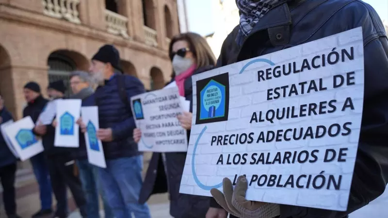 Un grupo de personas con pancartas de 'Regulación Estatal de alquileres a precios adecuados a los salarios de la población' durante una concentración de la Plataforma de Afectados por la Hipoteca (PAH) para exigir una ley de derecho a la vivienda, a 28 de