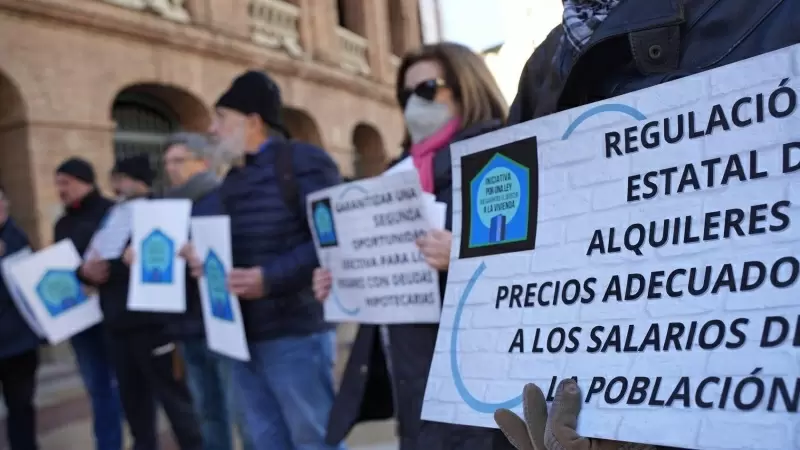 Un grupo de personas con pancartas de 'Regulación Estatal de alquileres a precios adecuados a los salarios de la población' durante una concentración de la Plataforma de Afectados por la Hipoteca (PAH) para exigir una ley de derecho a la vivienda, a 28 de