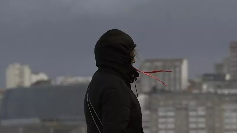 Una mujer se cubre con la capucha durante el frente meteorológico, a 23 de febrero de 2024, en A Coruña, Galicia (España).