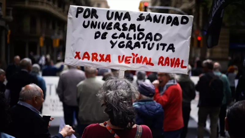 Una mujer sujeta un cartel de protesta durante una manifestación contra la privatización de la sanidad, a 7 de abril de 2024, en Barcelona, Catalunya (España).