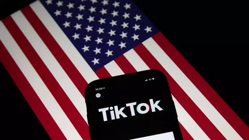 Un móvil con la aplicación China TikTok, sobre una bandera de EEUU.