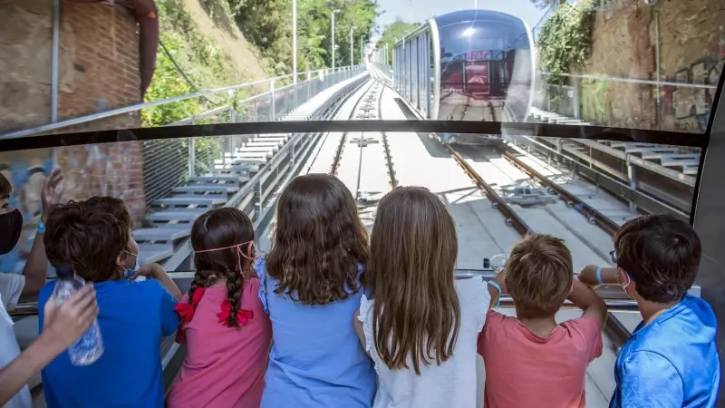 Diversos nens observen la Cuca de Llum, el funicular del Tibidabo