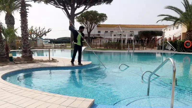 Un treballador netejant la piscina del càmping Les Medes de l'Estartit