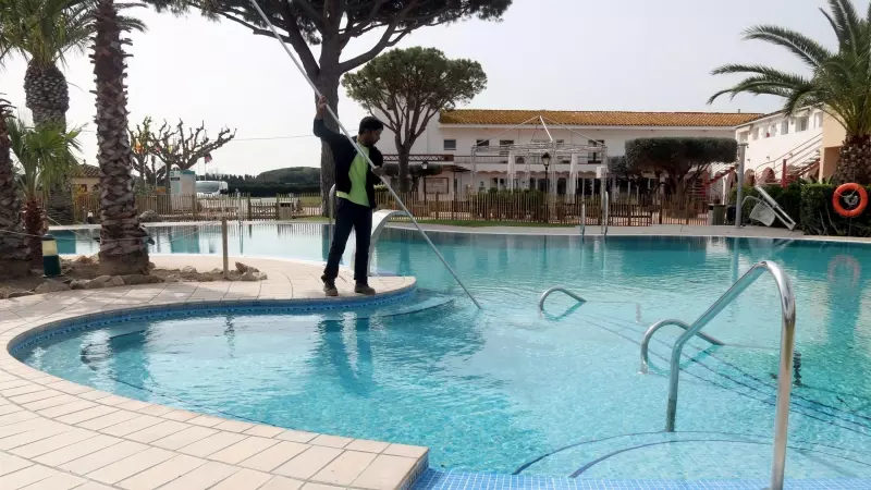Un treballador netejant la piscina del càmping Les Medes de l'Estartit