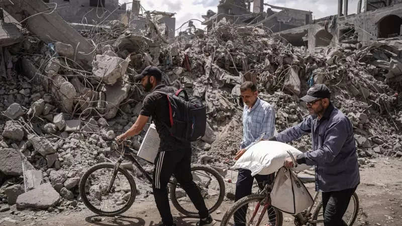 28/04/2024 Palestinos caminan frente a la destrucción en el campo de Nuseirat, en la Franja de Gaza, a 27/04/2024.