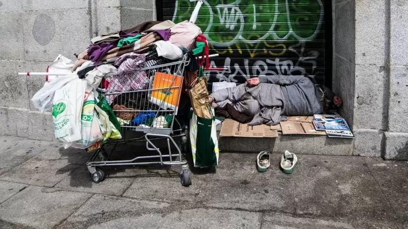 Una persona sin hogar duerme en una calle de Madrid. Imagen de archivo.