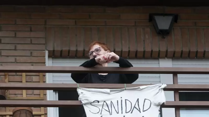 Una vecina coloca una pancarta que reza 'Sanidad Pública' para apoyar una manifestación por la sanidad pública en Villa de Vallecas, a 5 de marzo de 2023, en Madrid (España).