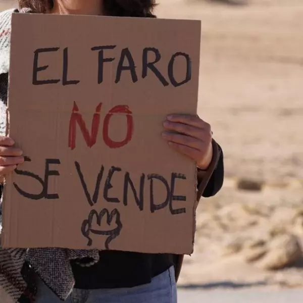 Una manifestante con un cartel de 'El faro no se vende'.