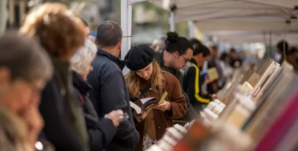 Varias personas miran libros en un puesto durante el día de Sant Jordi 2024, a 23 de abril de 2024, en Barcelona.