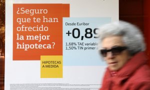 Una mujer pasa junto a una publicidad de hipotecas en una sucursal de Bankinter. REUTERS/Susana Vera