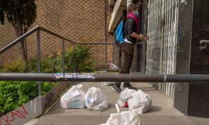 Una voluntaria de la Red de Cuidados Antirracistas lleva comida al domicilio de personas migrantes vulnerables durante el estado de alarma por el coronavirus.-MANU MITRU (CEDIDA)