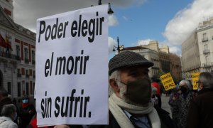 Un hombre con un cartel en el que se lee: `Poder elegir el morir sin sufrir´ durante una concentración de Derecho a Morir Dignamente en la Puerta del Sol, en Madrid.