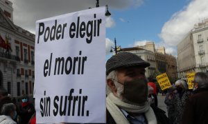 Un hombre con un cartel en el que se lee: `Poder elegir el morir sin sufrir´ durante una concentración de Derecho a Morir Dignamente en la Puerta del Sol, en Madrid (España), a 18 de marzo de 2021.