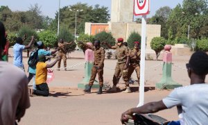 Soldados del ejército piden a las personas que se alejen mientras se reúnen frente al campamento militar Guillaume Ouedraogo para mostrar su apoyo a los militares protagonistas del golpe de Estado en Burkina Faso, este lunes 24 de enero de 2022.