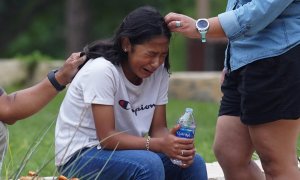 Una niña llora, consolada por dos adultos, afuera del Centro Cívico Willie de Leon, donde se ofrecerá asesoramiento de duelo en Uvalde, Texas, el 24 de mayo de 2022.
