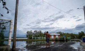 Un hombre examina su vecindario frente al mar mientras el huracán Fiona y sus fuertes lluvias se acercan en Guayanilla, Puerto Rico.