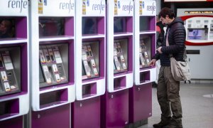 Un hombre en las máquinas auto-venta de Renfe, en la estación Puerta de Atocha-Almudena Grandes con motivo del inicio del Puente de la Constitución, a 2 de diciembre de 2022, en Madrid.