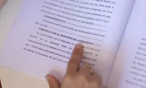 Una mujer señala una escritura de compraventa de una hipoteca, a 30 de mayo de 2022