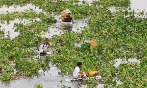 Niños filipinos atraviesan un río contaminado con barcas hechas por ellos mismos para recolectar elementos reutilizables en Manila, Filipinas/REUTERS