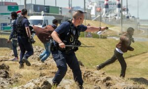 Fotografía de junio de 2015 de un policía gaseando a un inmigrante en Calais. - AFP