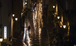 Una mujer camina sola por la calle bajo la luz de las farolas. EFE