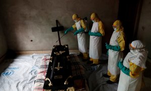 Un equipo médico desinfecta una habitación durante un funeral de un sospechoso de haber muerto por ébola - REUTERS/Goran Tomasevic