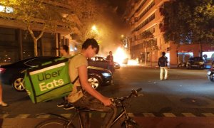 Un rider te trae comida a casa mientras arde Barcelona: la foto que nos debería hacer reflexionar