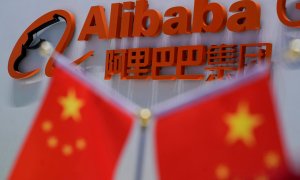 El logo del gigante chino de Internet Alibaba junto a unas banderas chinas, en su sede en Hangzhou. REUTERS/Aly Song
