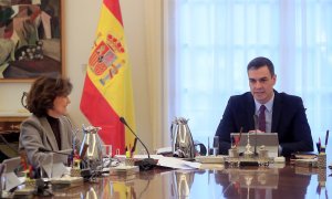 14/01/2020.- El presidente del Gobierno, Pedro Sánchez (i), conversa con la vicepresidenta primera, ministra de Presidencia y Relaciones con las Cortes, Carmen Calvo, al inicio del primer Consejo de Ministros, celebrado este martes en el Palacio de la Mon