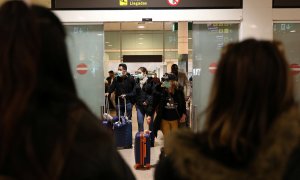 Pasajeros con mascarilla procedentes de Italia llegan al aeropuerto de Barcelona. - REUTERS