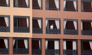 Un turista se asoma desde el balcón de su habitación en el hotel del sur de Tenerife. - EFE