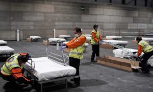 Operarios ayudando a construir el hospital de campaña en el Ifema de Madrid. / EFE