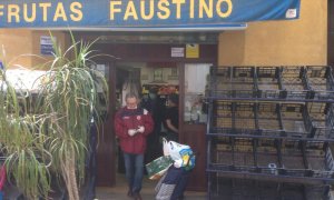 Un cliente sale de una frutería, en Sevilla. Raúl Bocanegra