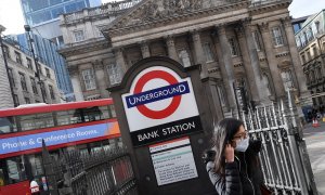 Una joven con mascarilla sale de la boca de metro junto a la sede del Banco de Inglaterrra, en la City de Londres. REUTERS/Toby Melville