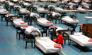 Miembros de la Cruz Roja instalando esta semana material en el pabellón de Les Comas de Igualada (Barcelona) donde se está preparando un hospital de campaña. EFE/Susanna Sáez