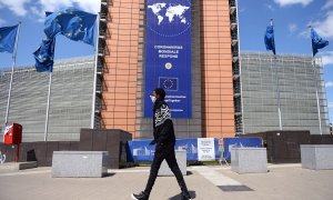 Un hombre con mascarilla pasa por delante de la sede de la Comisión Europea, en Bruselas. REUTERS/Johanna Geron