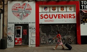 Una mujer con mascarilla pasa por delante de una tienda de souvenirs cerrada en el centro de Madrid. REUTERS/Susana Vera