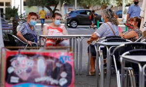 Una vecinas descansan en la terraza de un bar del barrio de la Pastoreta de Reus (Tarragona) donde este lunes se han reanudado los cribados masivos de PCR a los vecinos. /EFE