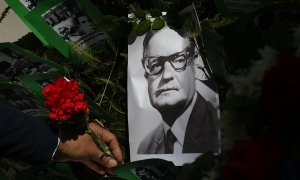 Un hombre deja una flor sobre la imagen del presidente chileno Salvador Allende, este viernes en Santiago. Chile conmemora el 47 aniversario del golpe de Estado de Augusto Pinochet, que derrocó al Gobierno de Salvador Allende, en plena pandemia de corona