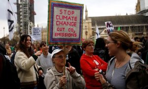 Una mujer sujeta una pancarta contra en protesta contra el cambio climático y las emisiones de CO2. REUTERS/Henry Nicholls
