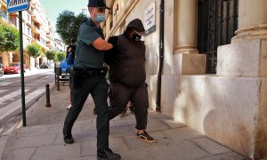 Un agente de la Guardia Civil traslada al Juzgado de Instrucción número 1 de Ontinyent, en Valencia, a uno de los detenidos por su supuesta participación en una violación grupal a una menor de 14 años en la localidad valenciana de l'Olleria que se produj
