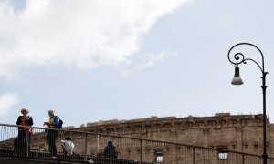 Dos mujeres llevan mascarillas cerca del Coliseo romano en Italia. REUTERS / Yara Nardi