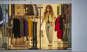 Una trabajadora de una tienda de ropa tras abrir el comercio. E.P./Eduardo Sanz